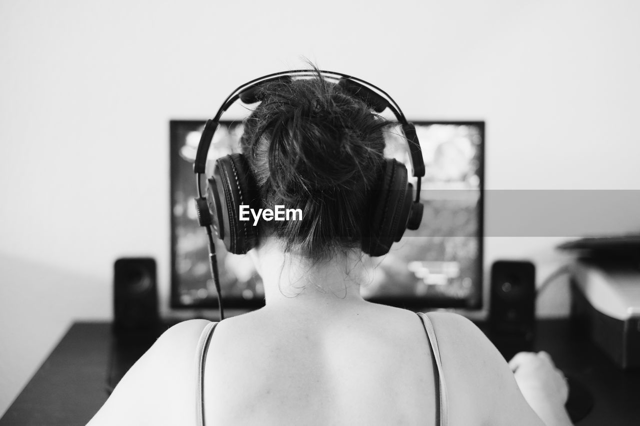 Rear view of woman listening to music