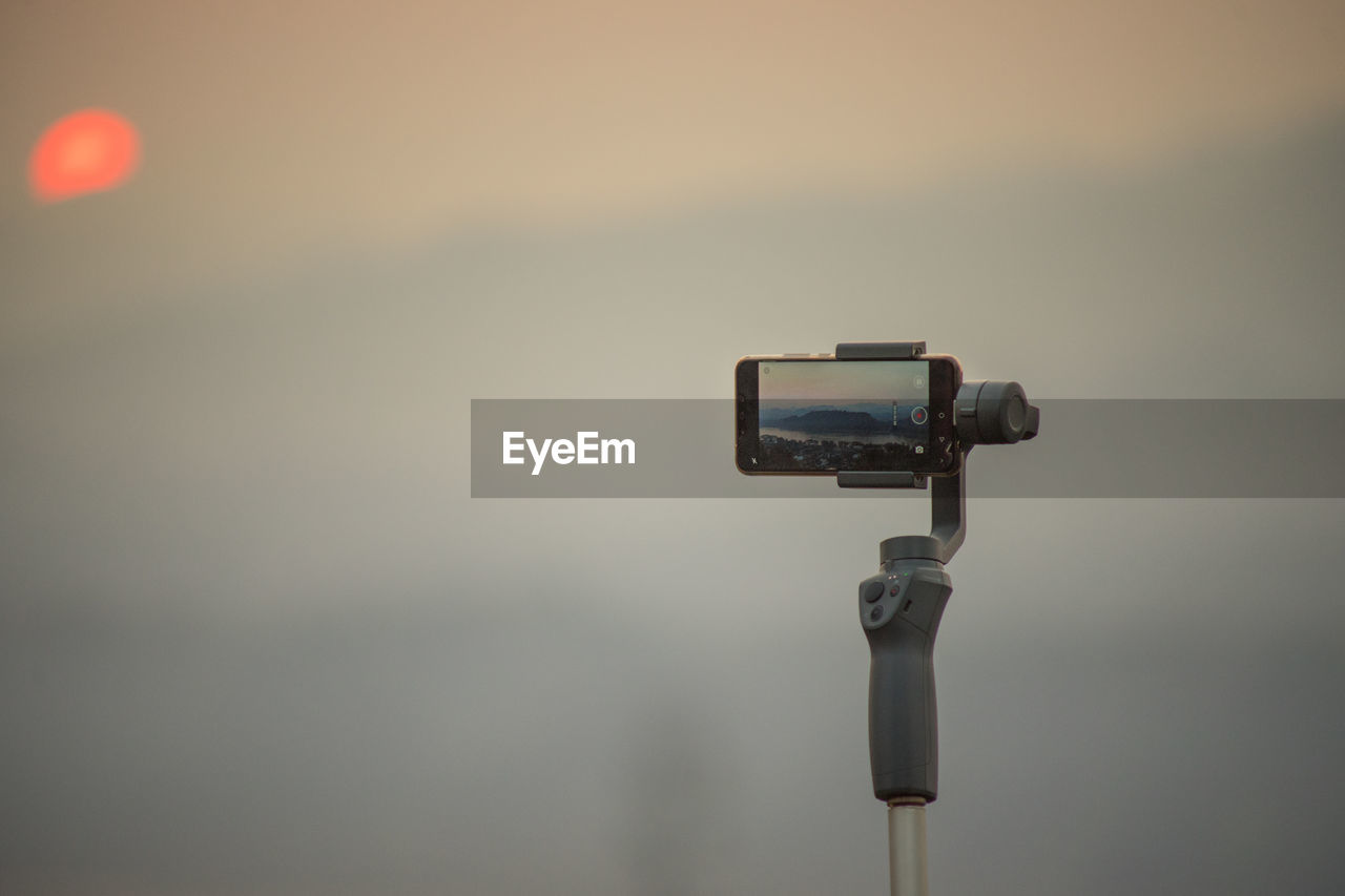 LOW ANGLE VIEW OF CAMERA AGAINST SKY