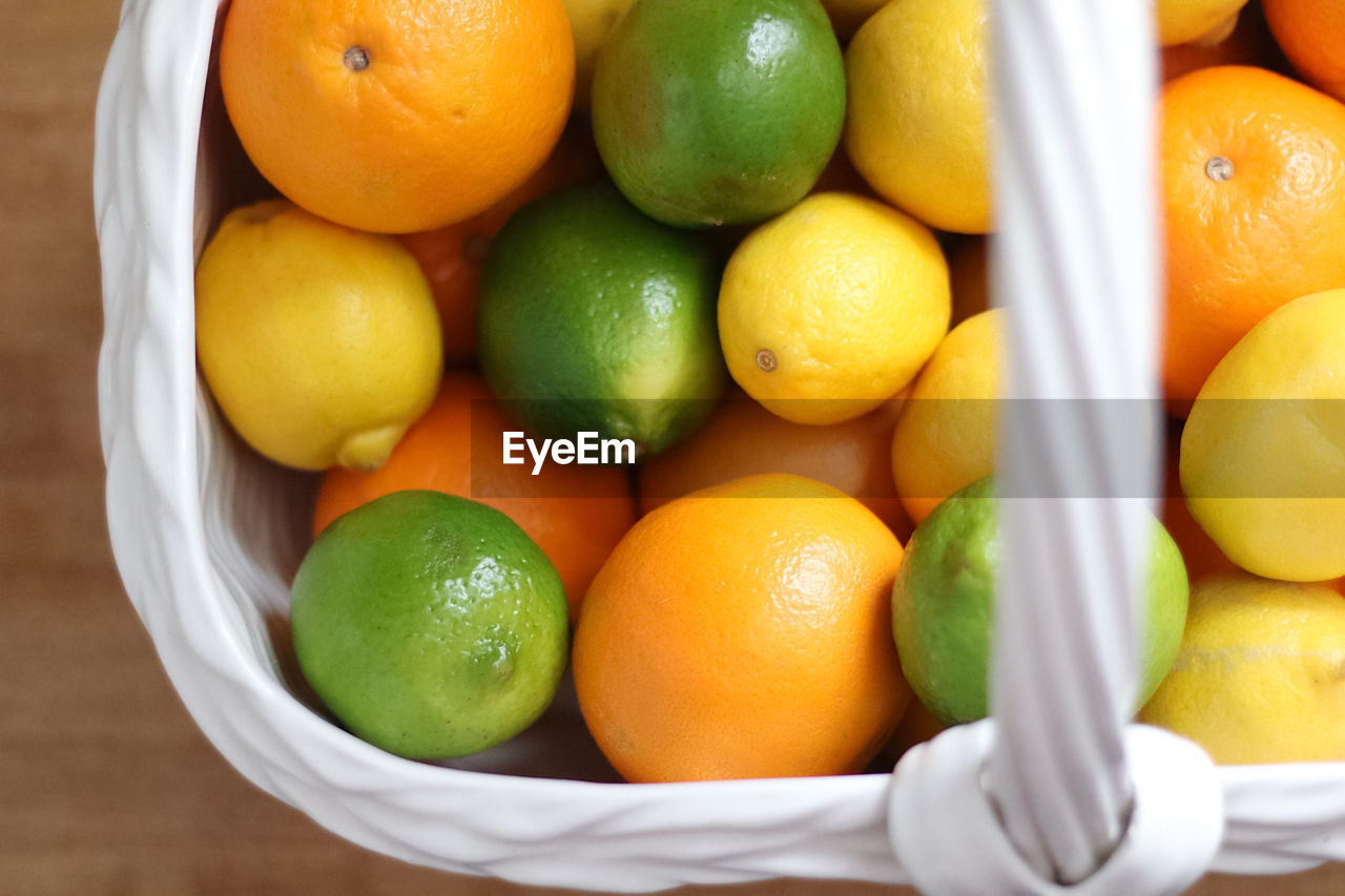 High angle view of variety of citrus in a ceramic container. 