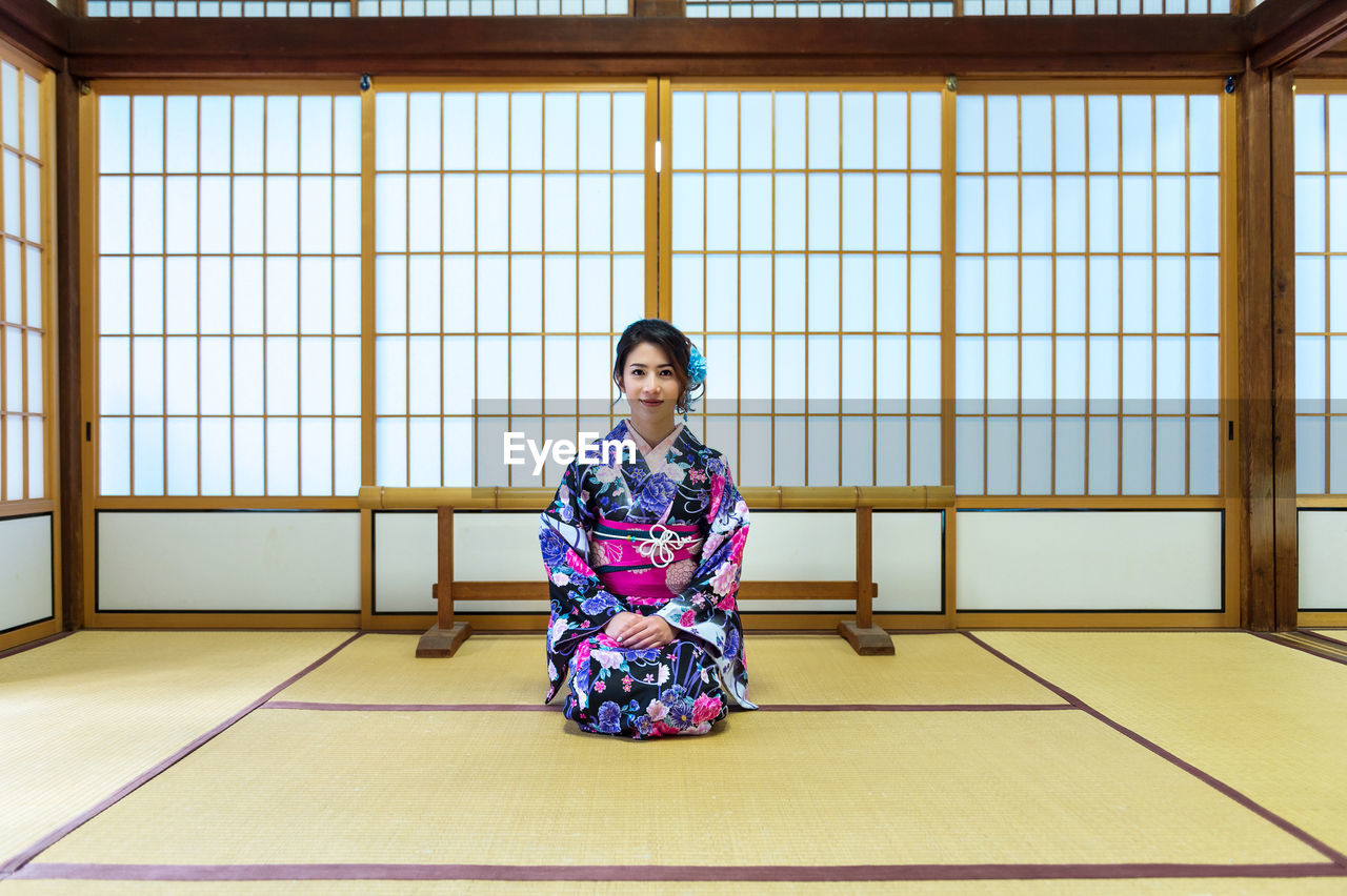 Portrait of woman kneeling at home