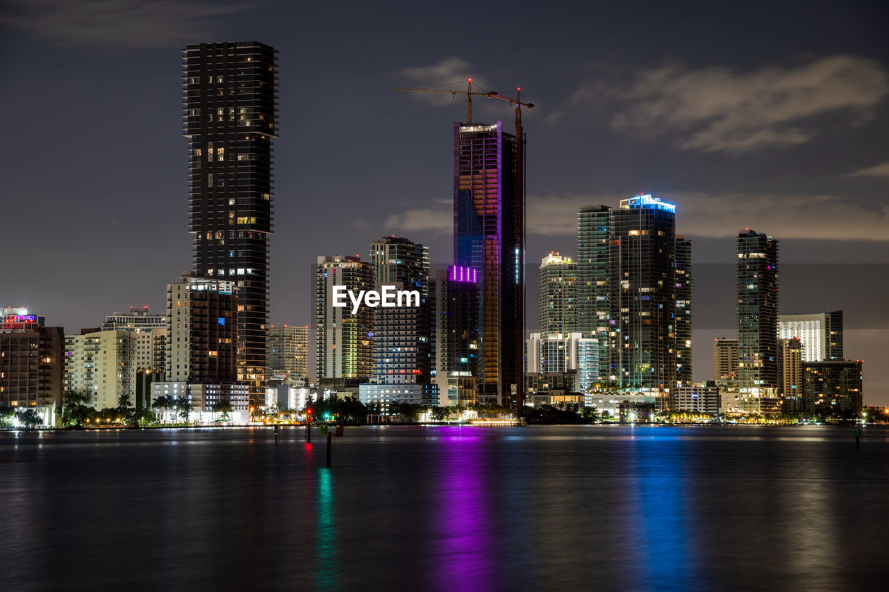 architecture, city, building exterior, built structure, office building exterior, skyline, skyscraper, building, landscape, metropolitan area, urban skyline, illuminated, cityscape, night, sky, metropolis, horizon, residential district, water, reflection, travel destinations, downtown district, dusk, urban area, office, city life, nature, waterfront, downtown, tower block, no people, evening, landmark, tower, business, travel, outdoors, financial district, development, cloud, river, long exposure, transportation, business finance and industry