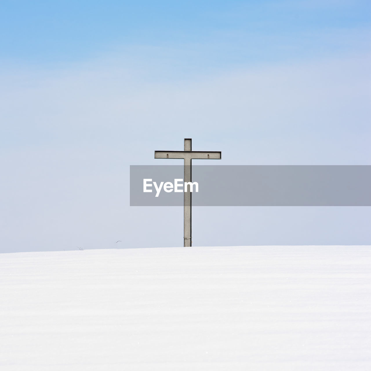 CROSS ON SNOW AGAINST SKY