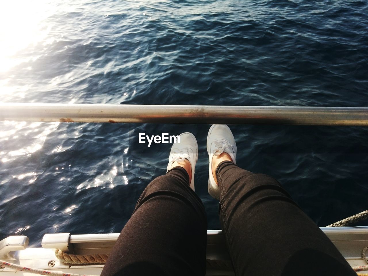 Low section of man sitting on boat over sea