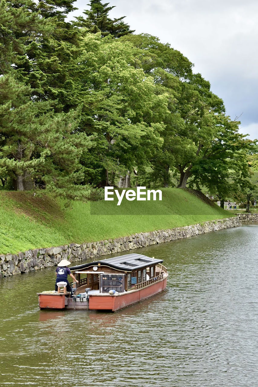 Boats in  the outer  moat of the hikone castle against trees
