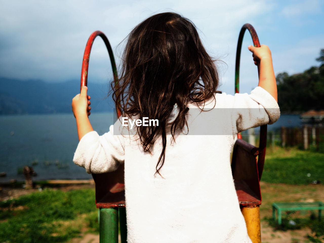 Rear view of girl on slide at park