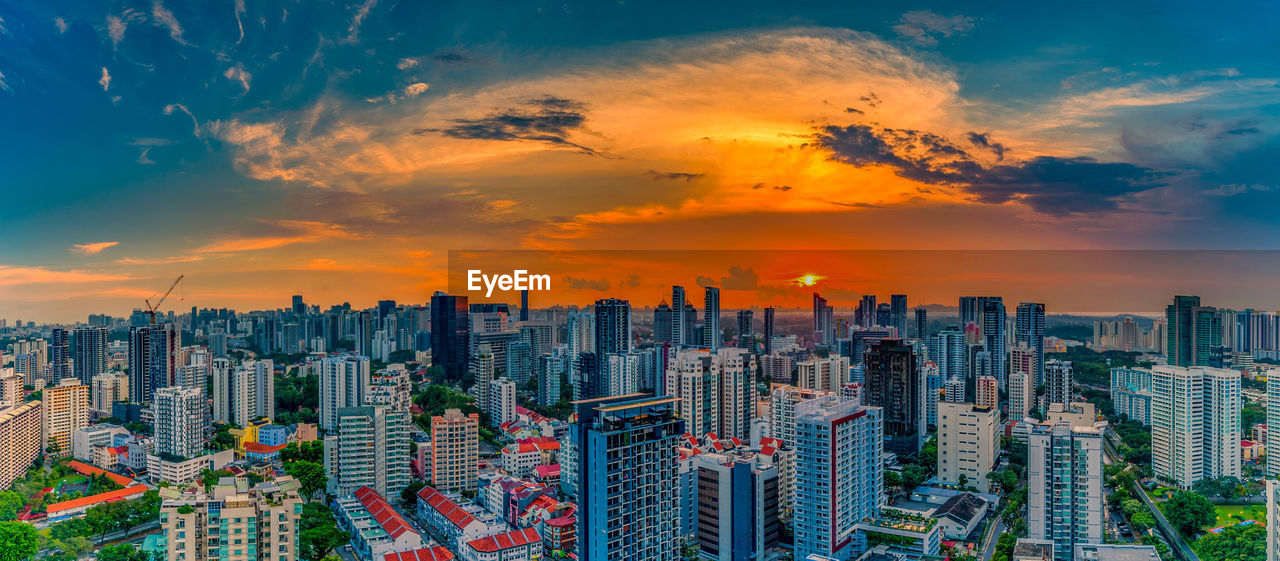 Aerial view of modern buildings against sky during sunset