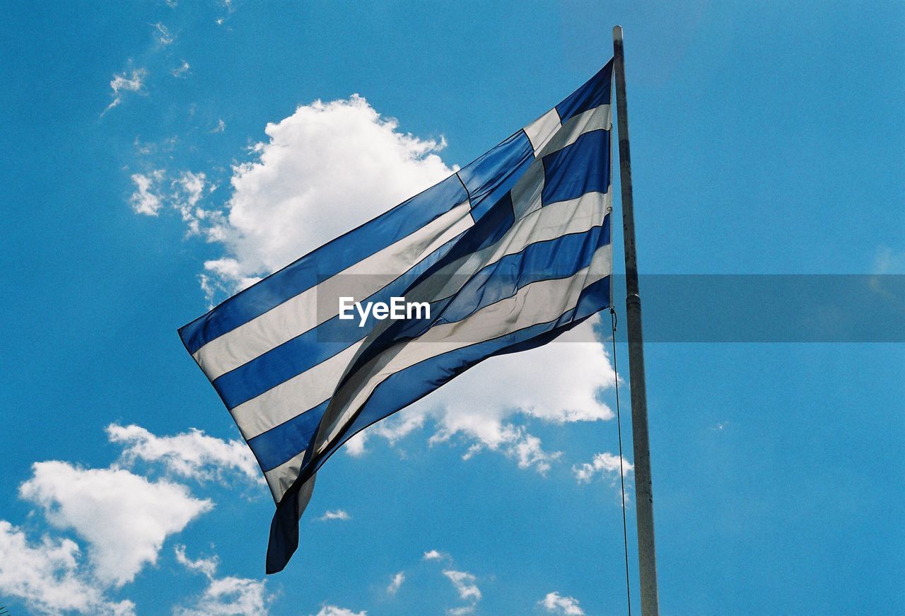 Low angle view of greek flag against blue sky