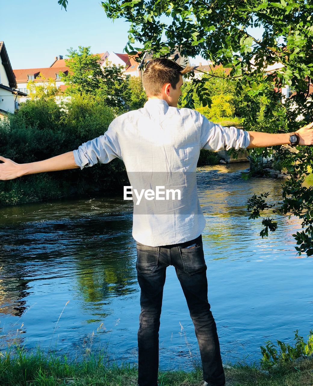 YOUNG MAN STANDING BY LAKE