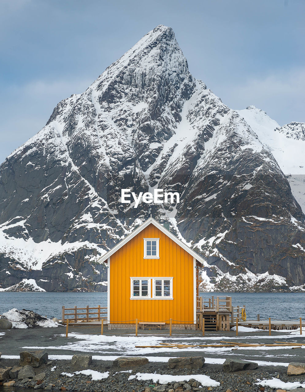 Yellow house against snowcapped mountain