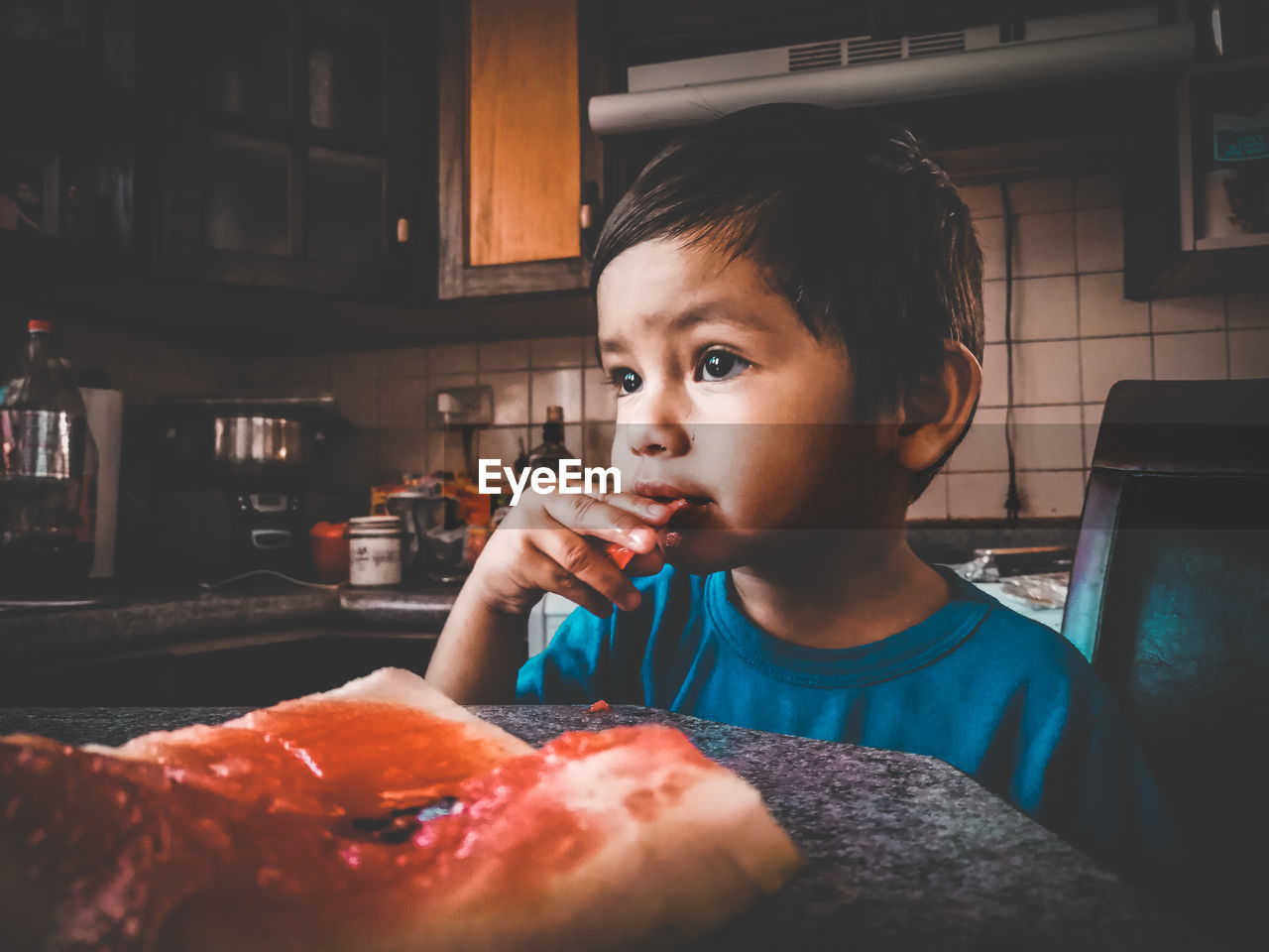 Portrait of boy eating food at home