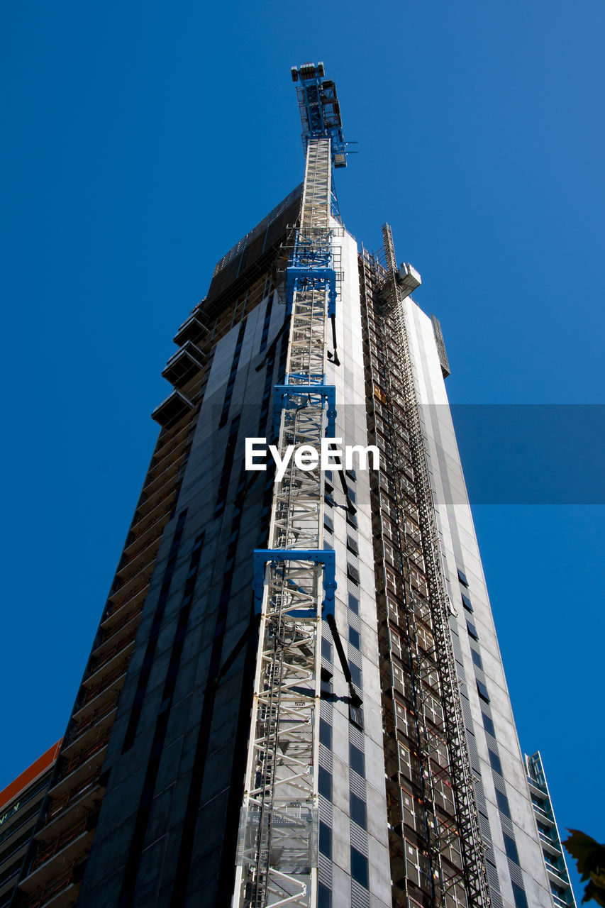 LOW ANGLE VIEW OF BUILDINGS AGAINST CLEAR BLUE SKY