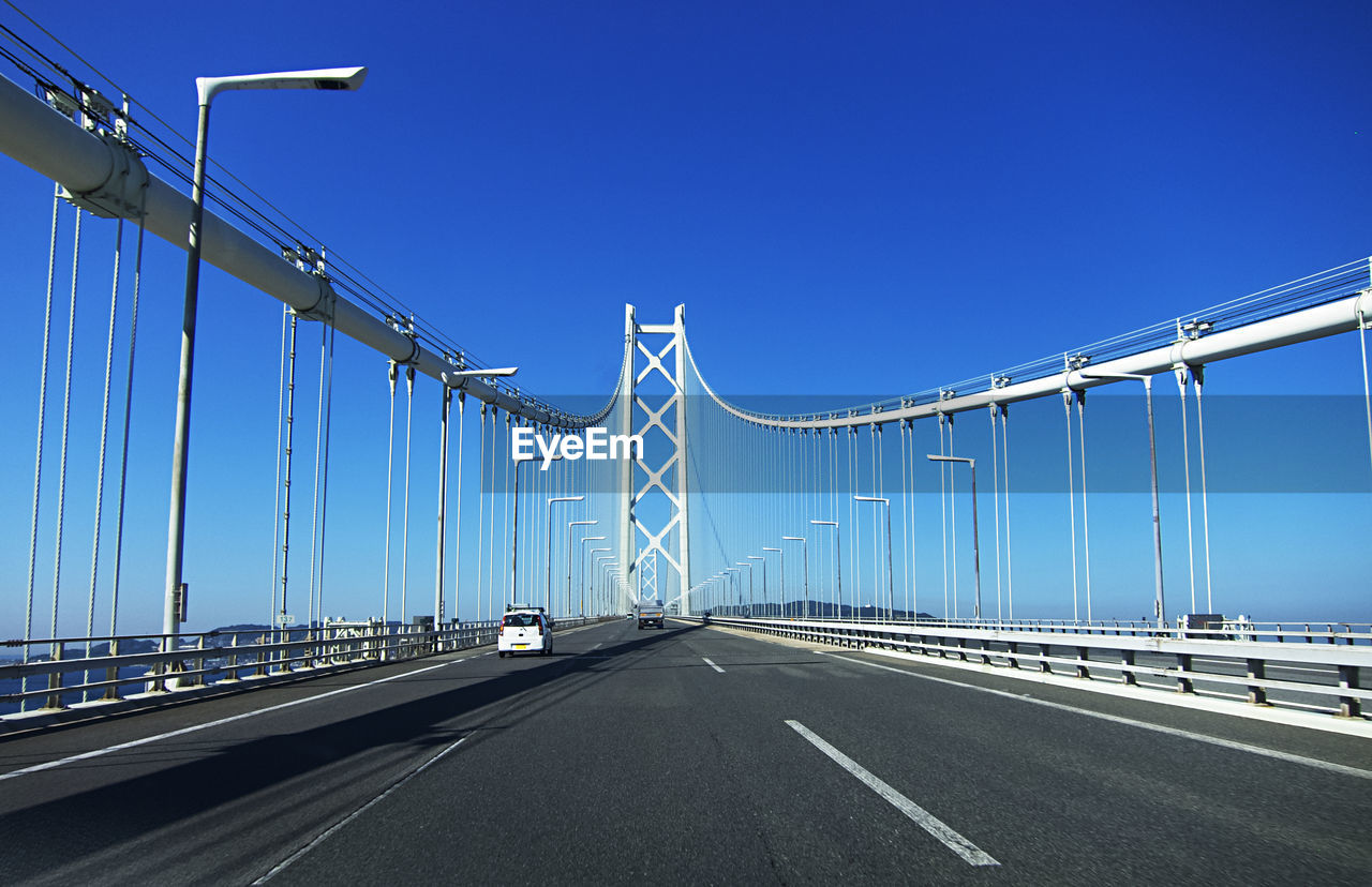 View of suspension bridge against clear blue sky