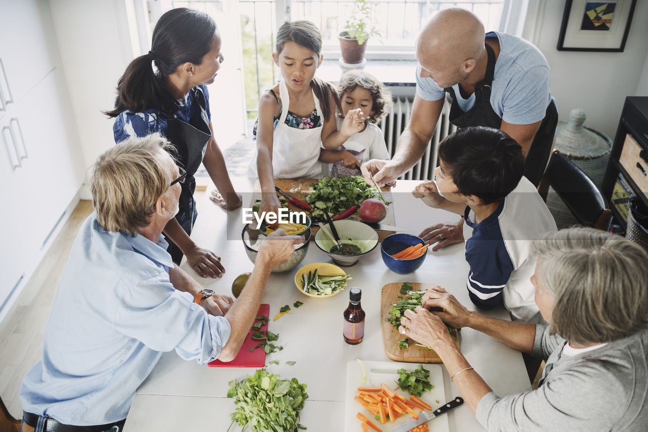 High angle view of family preparing asian food at table