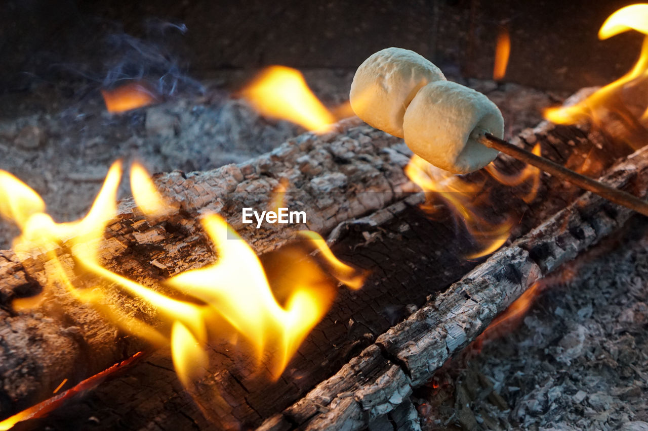 CLOSE-UP OF BONFIRE ON WOODEN LOG