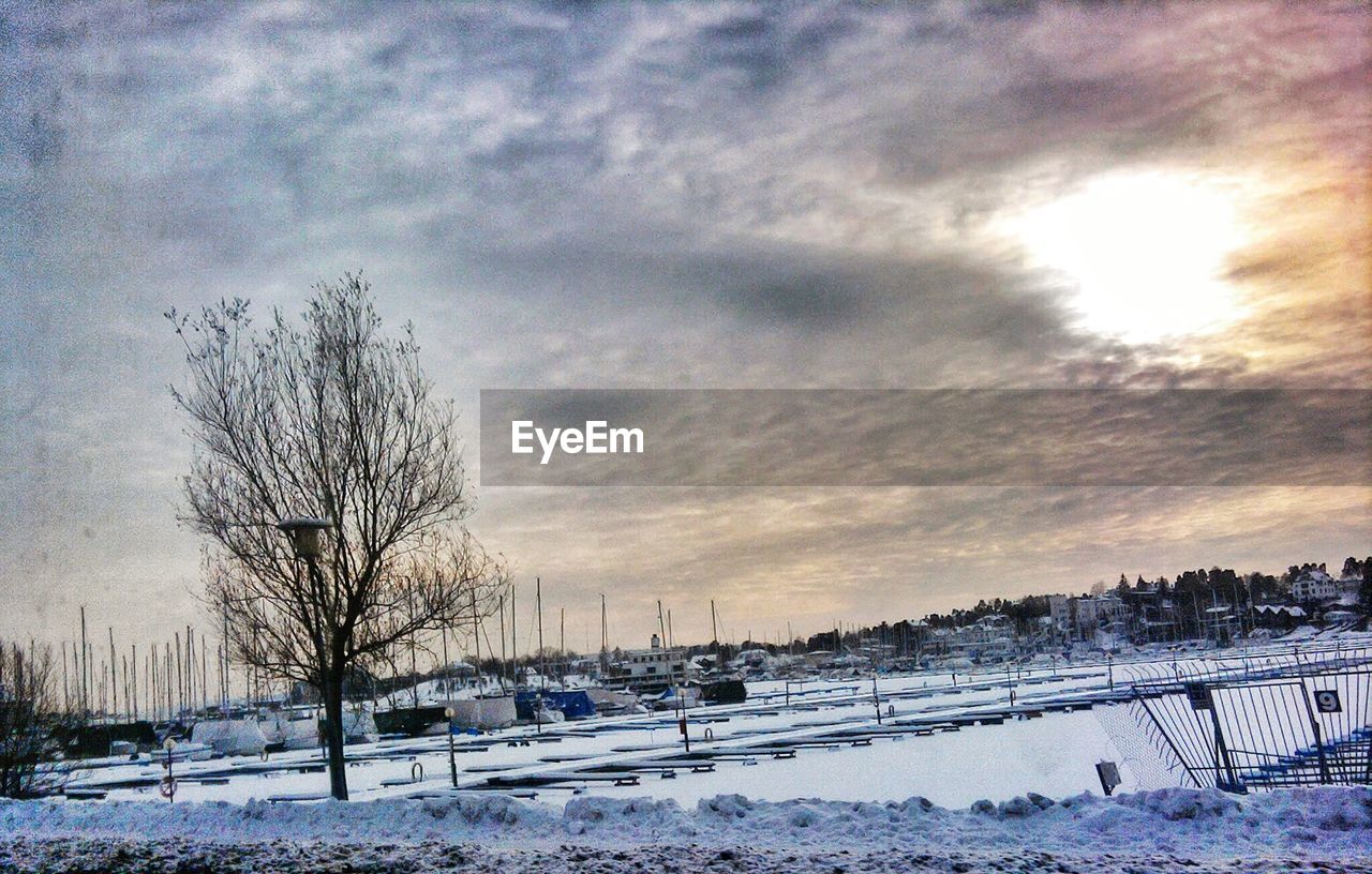 SNOW COVERED LANDSCAPE AGAINST CLOUDY SKY