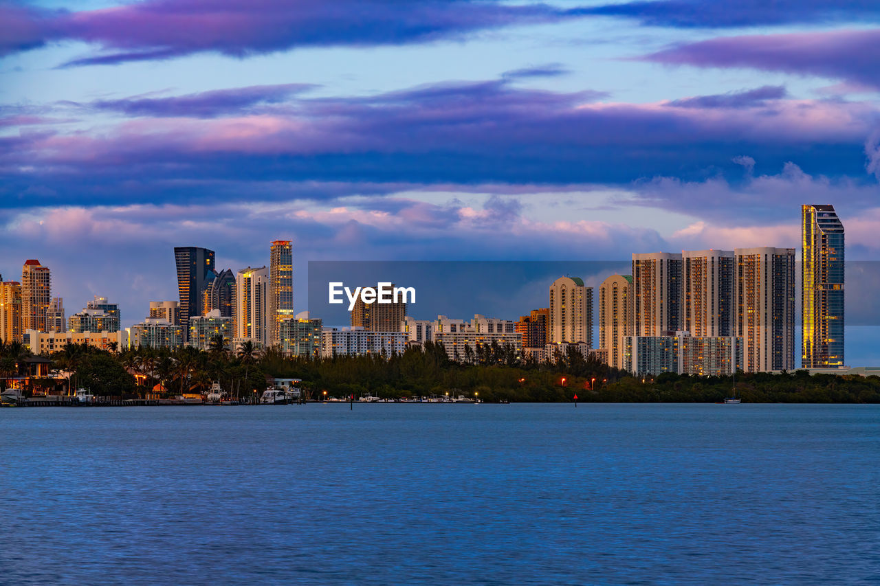 city, horizon, architecture, skyline, building exterior, built structure, building, landscape, skyscraper, office building exterior, urban skyline, sky, cityscape, dusk, water, downtown district, cloud, travel destinations, residential district, nature, city life, evening, sunset, urban area, office, downtown, reflection, travel, metropolis, illuminated, waterfront, no people, metropolitan area, sea, night, landmark, tower block, outdoors, business, dramatic sky, scenics - nature, environment, blue, twilight, street, tourism, financial district, transportation