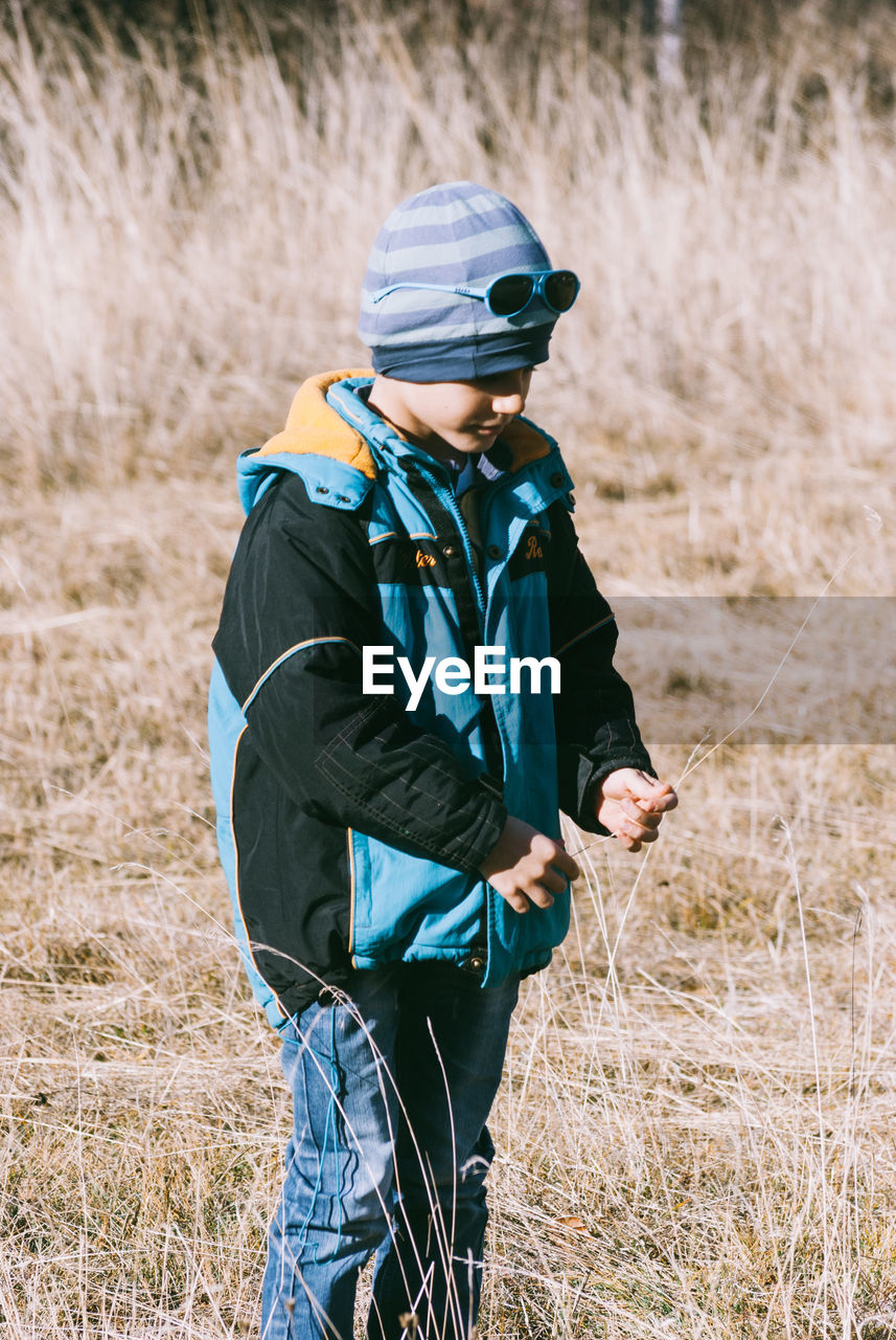 Cute boy standing on grassy field