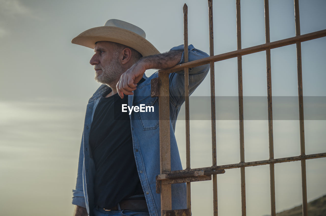 Portrait of adult man in cowboy hat on field