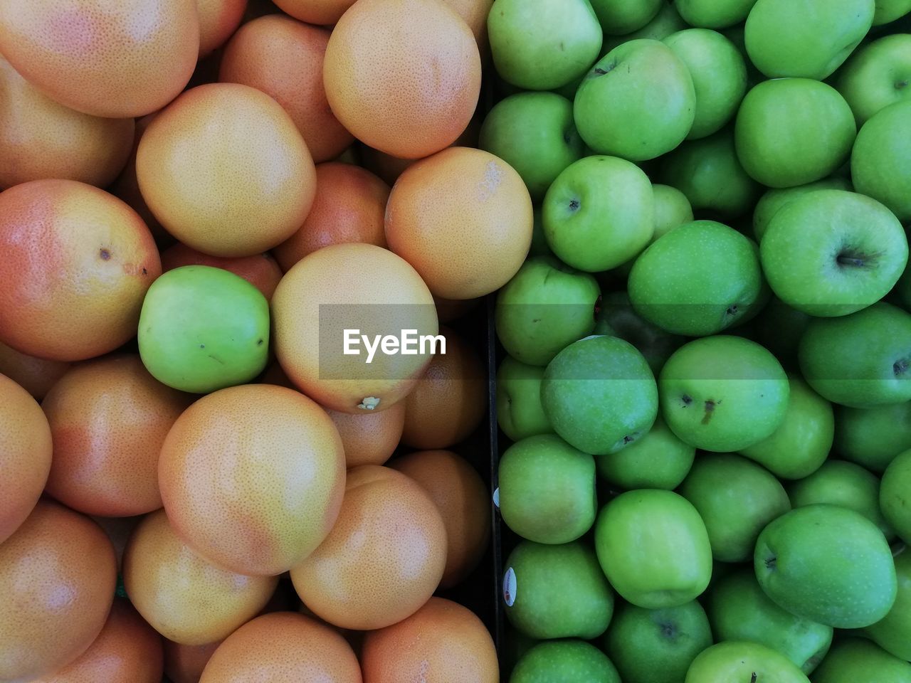 FULL FRAME SHOT OF GREEN FRUITS FOR SALE IN MARKET