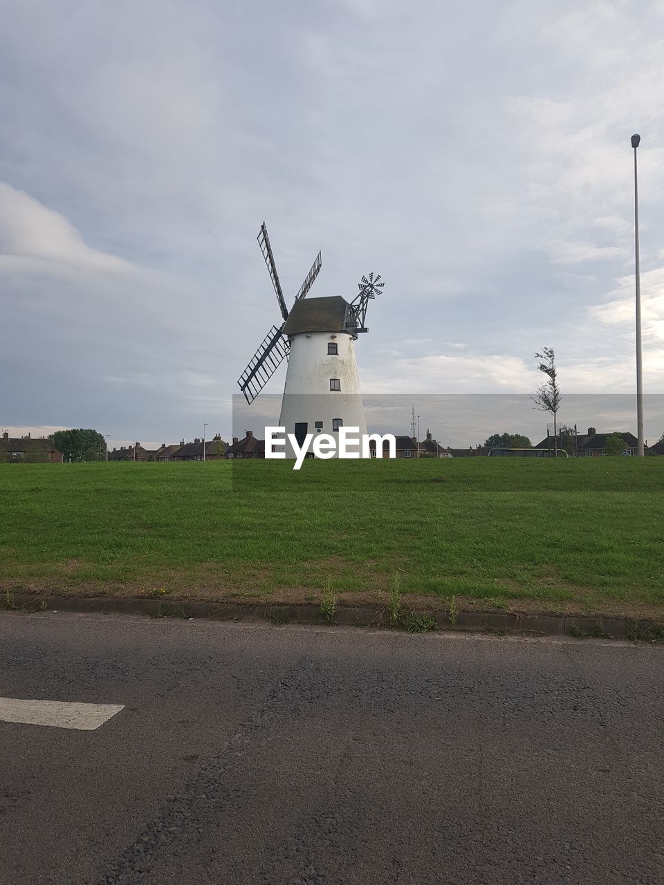 WINDMILL ON ROAD AGAINST SKY