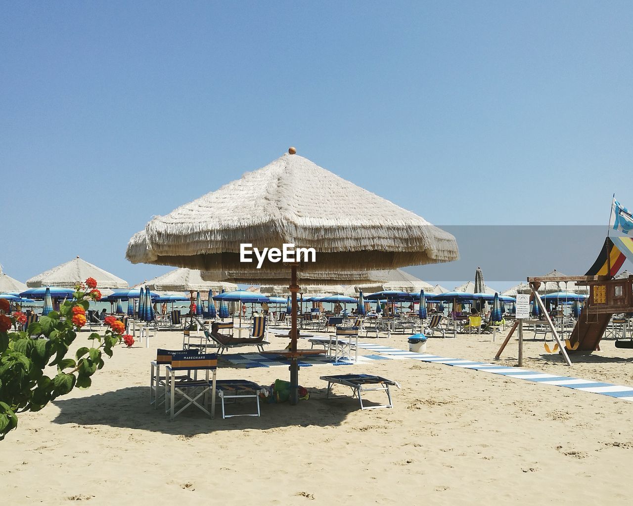 THATCHED ROOF ON BEACH AGAINST CLEAR SKY