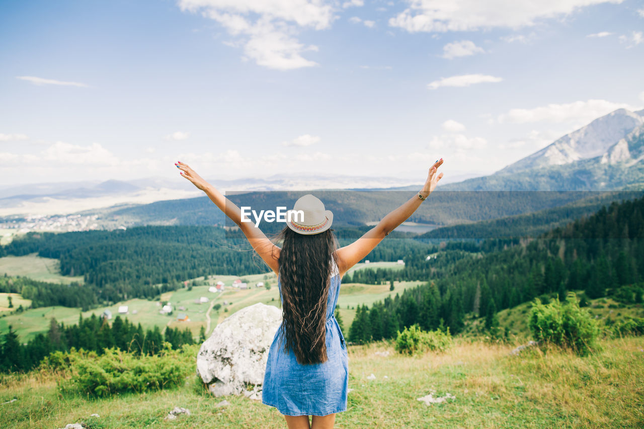 Rear view of woman on landscape against sky