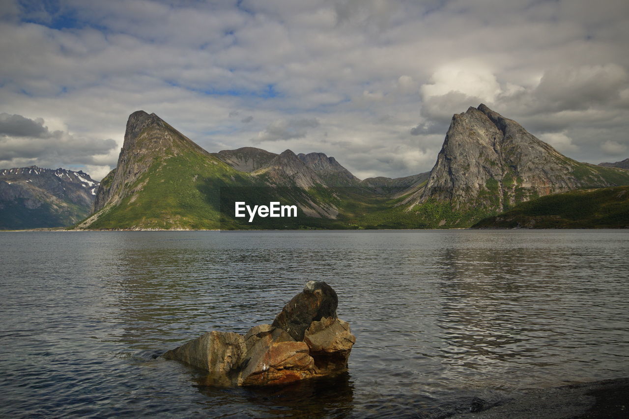 Scenic view of sea and mountains against sky