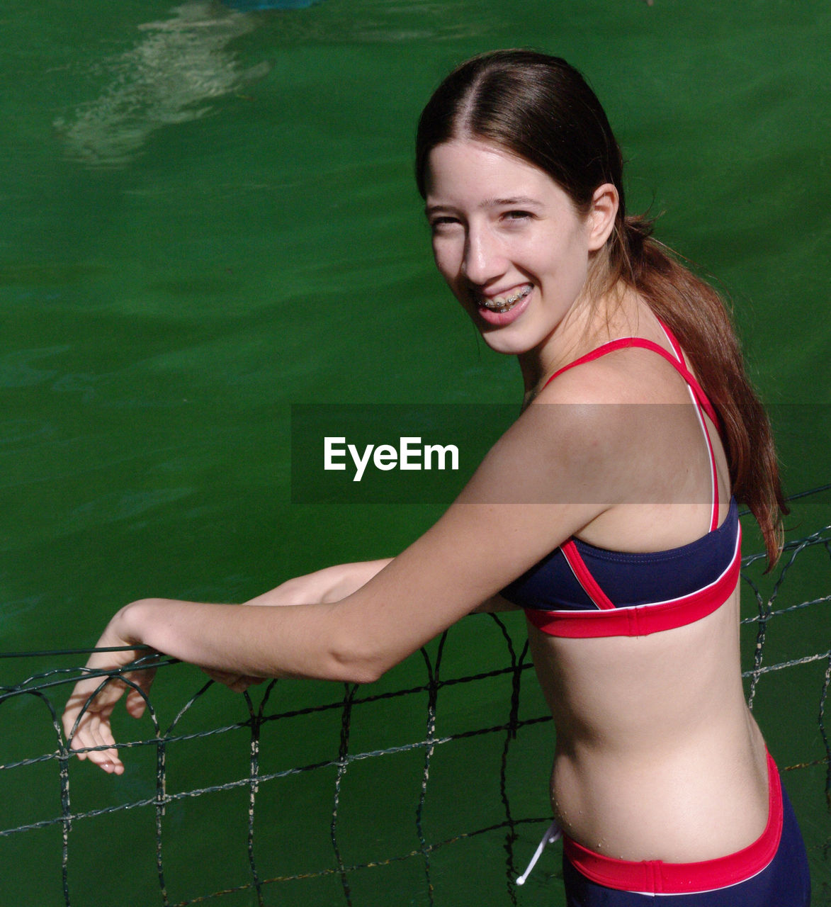 Portrait of smiling woman wearing bikini in lake