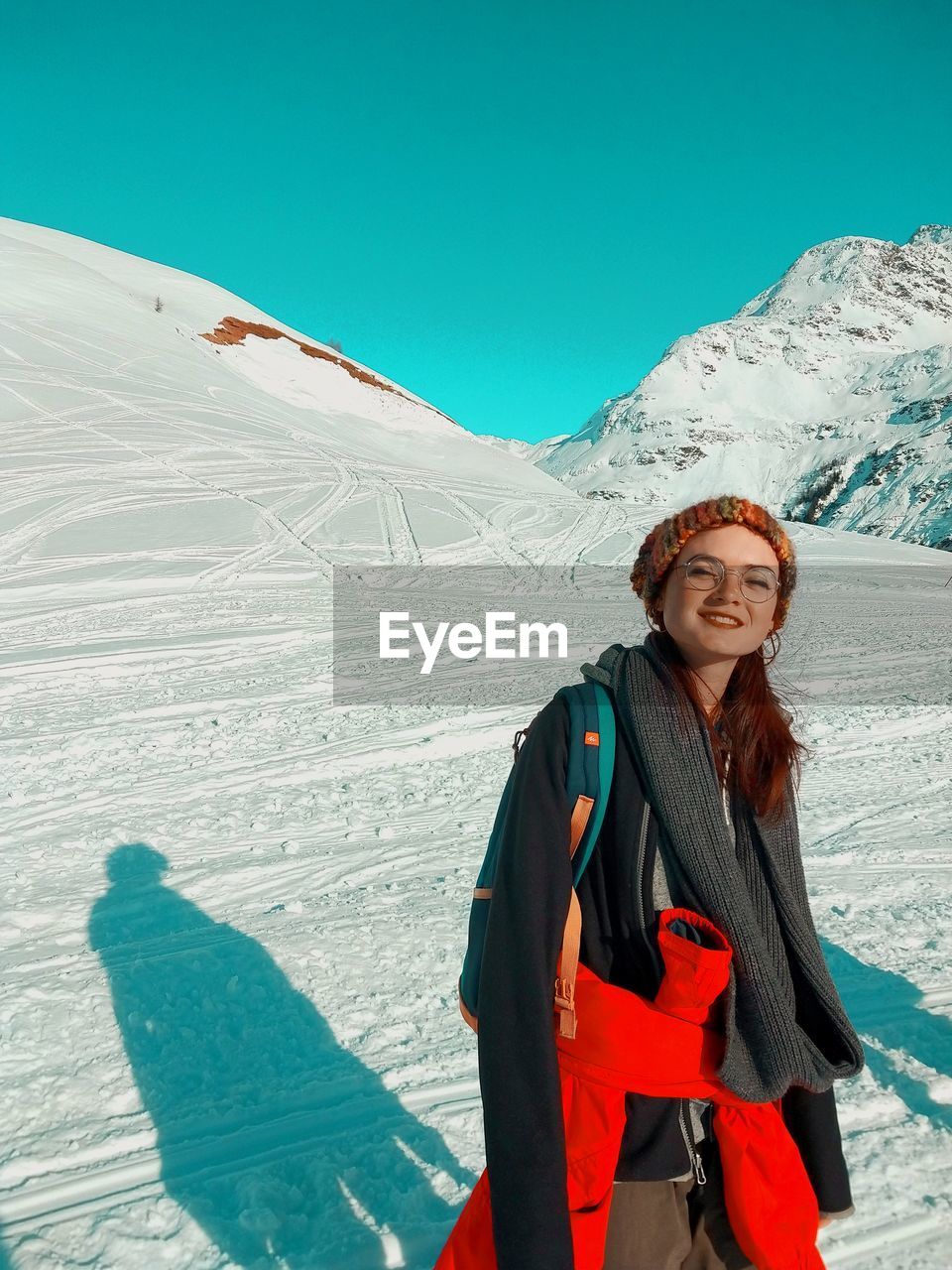 Full length of woman standing on snowcapped mountains during winter