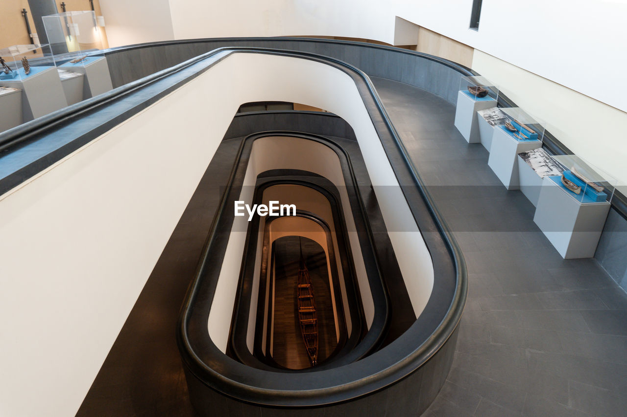 indoors, architecture, escalator, staircase, high angle view, no people, railing, built structure, business finance and industry, futuristic, technology