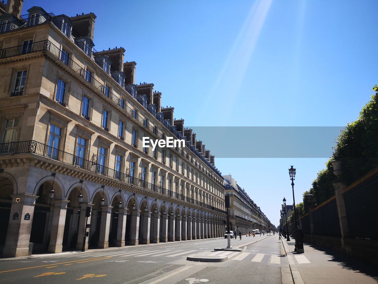 STREET AMIDST BUILDINGS IN CITY AGAINST SKY