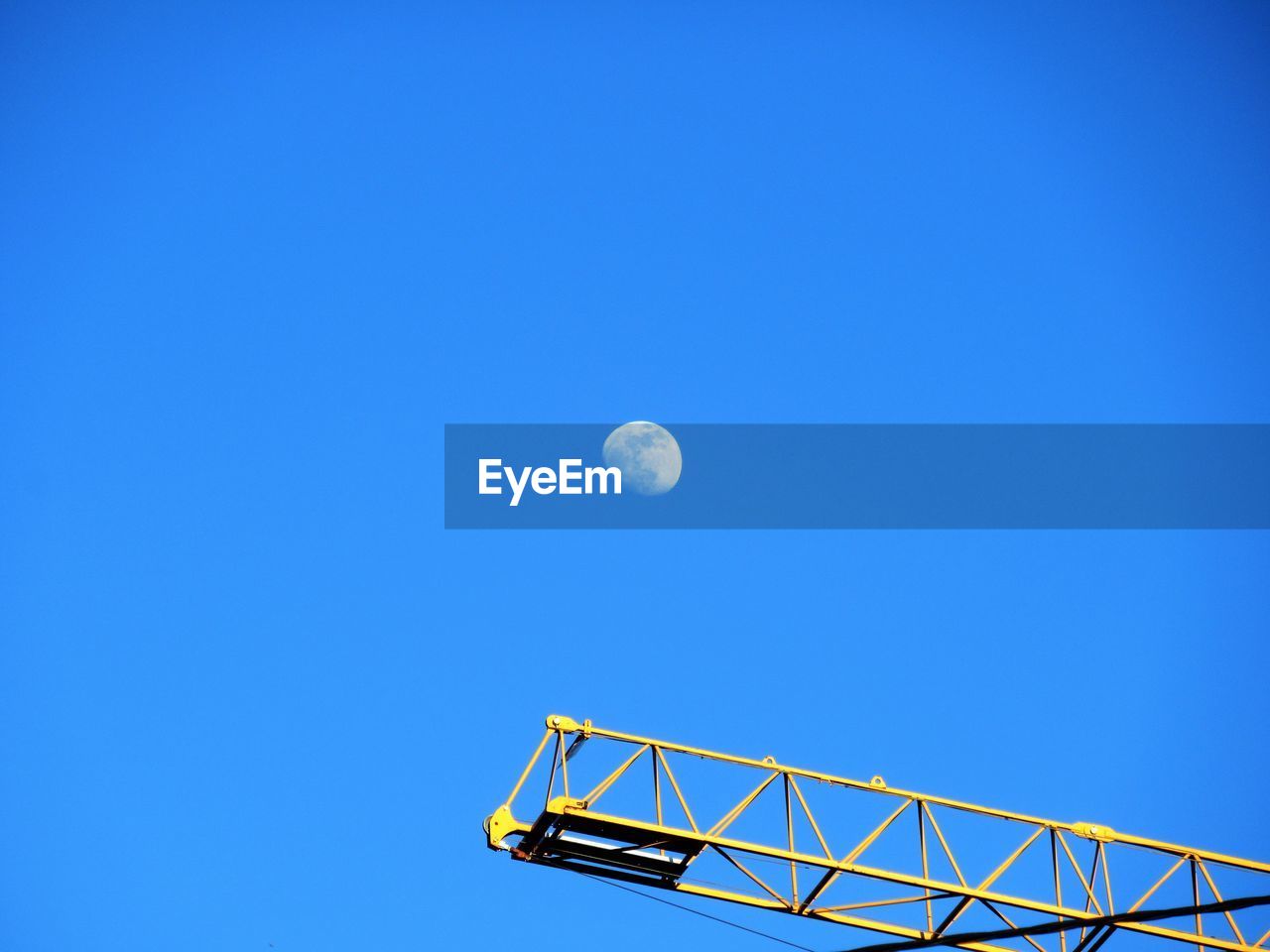 Low angle view of moon against clear blue sky