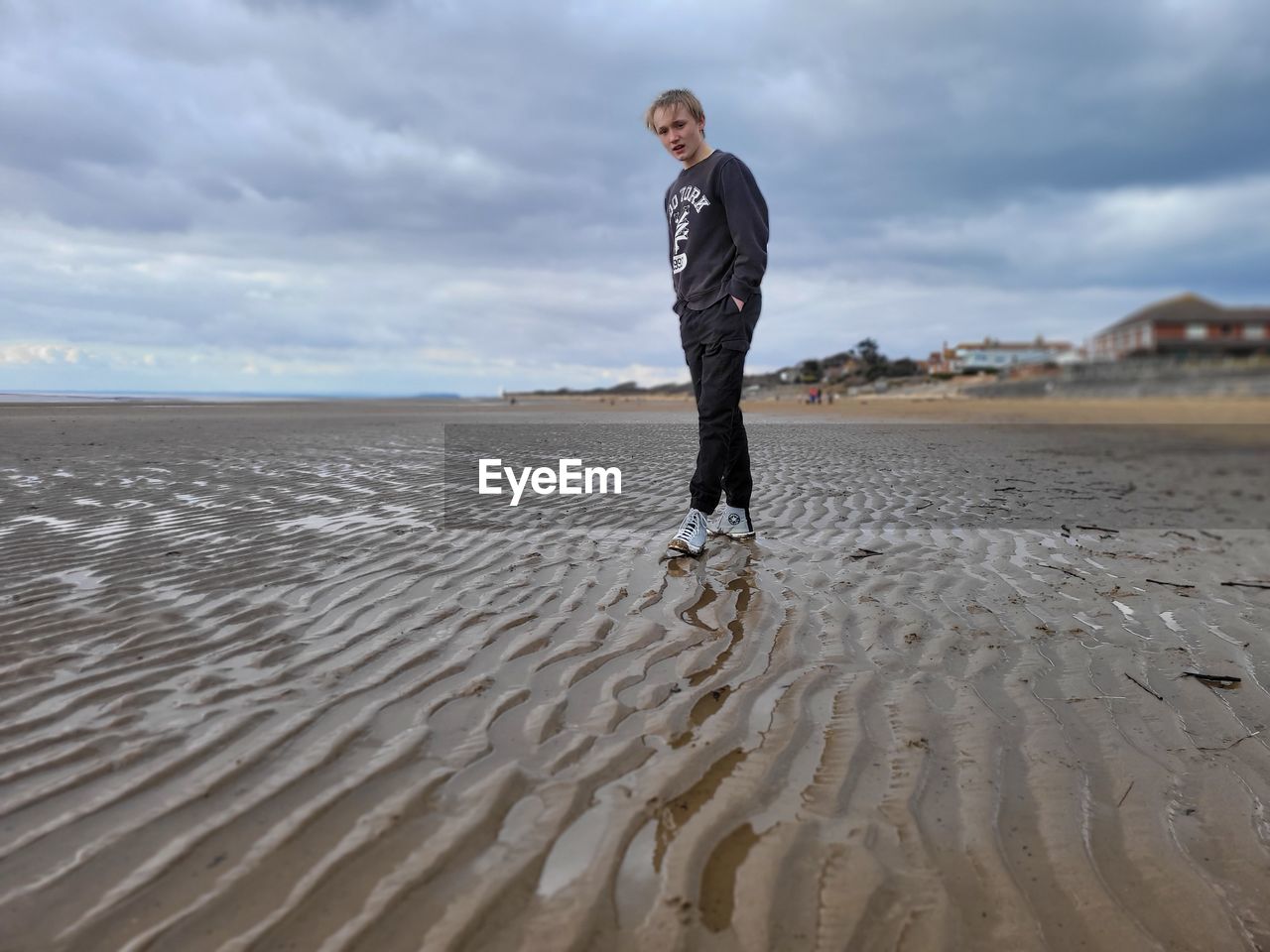 Full length of man standing at beach against sky