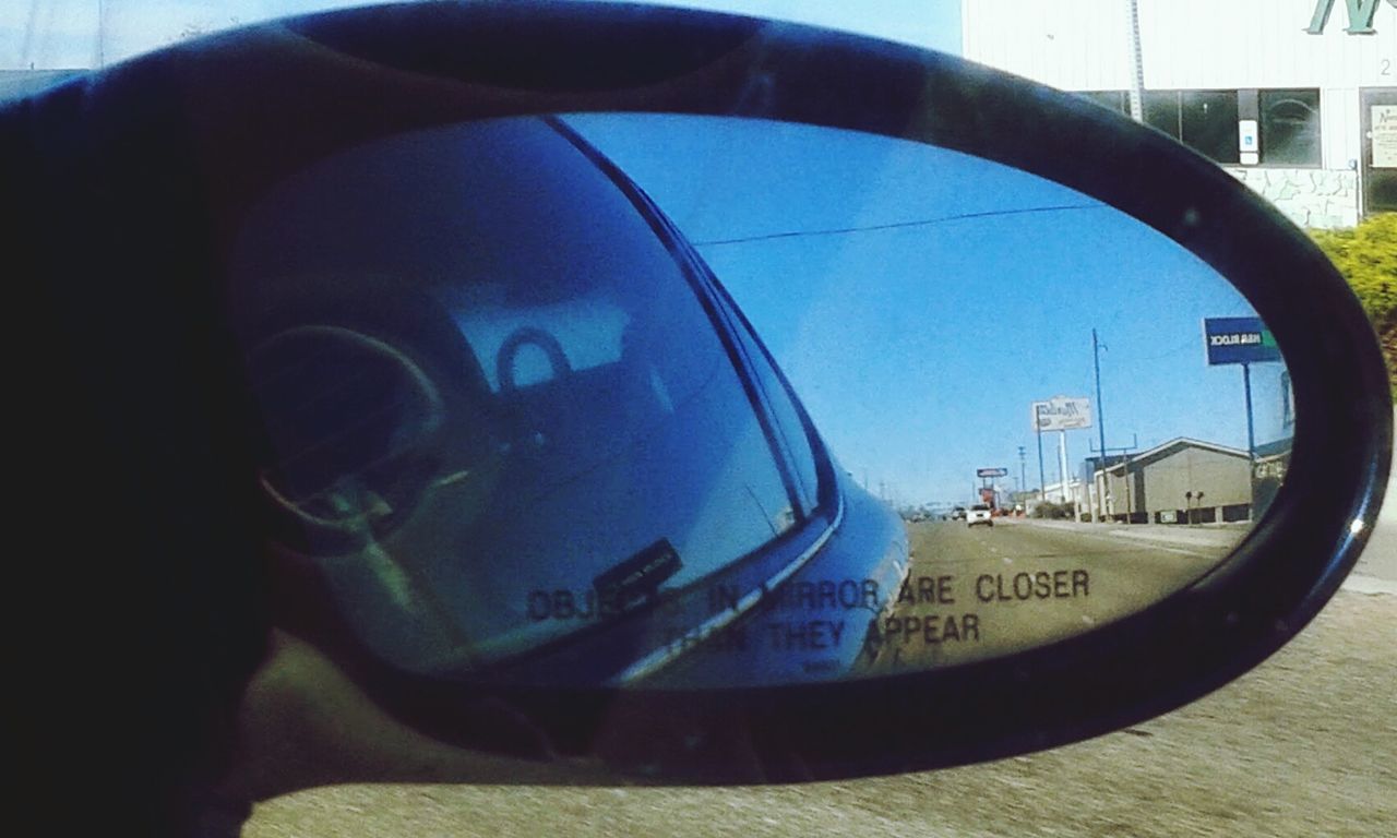 REFLECTION OF MAN ON SIDE-VIEW MIRROR