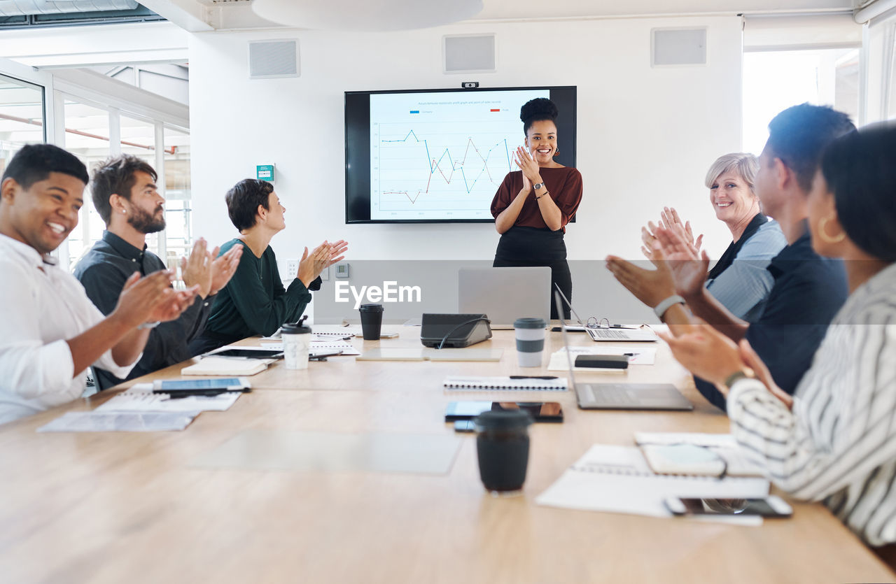 A business group clapping in a boardroom meeting. colleagues celebrating success at a presentation