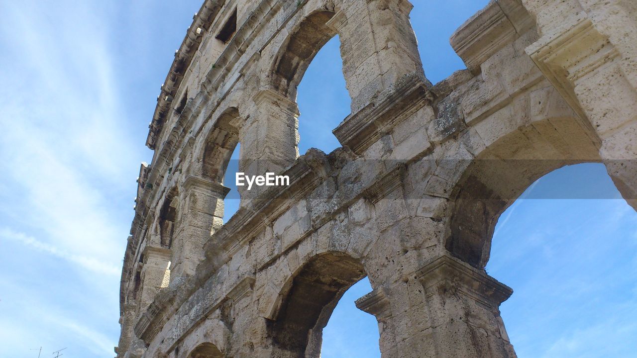 Low angle view of coliseum against sky