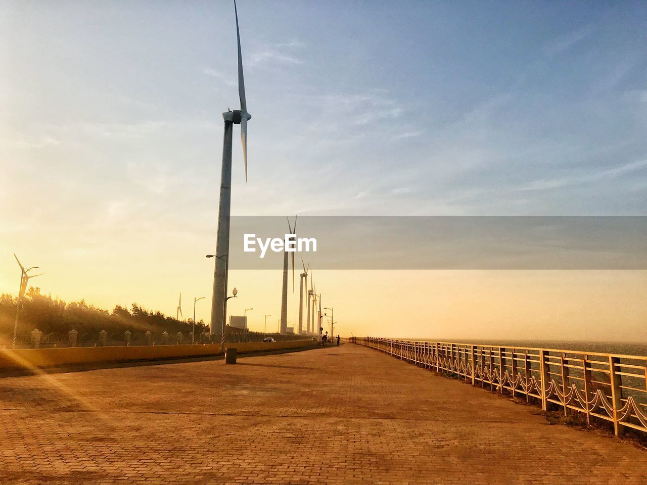 Road by bridge against sky during sunset