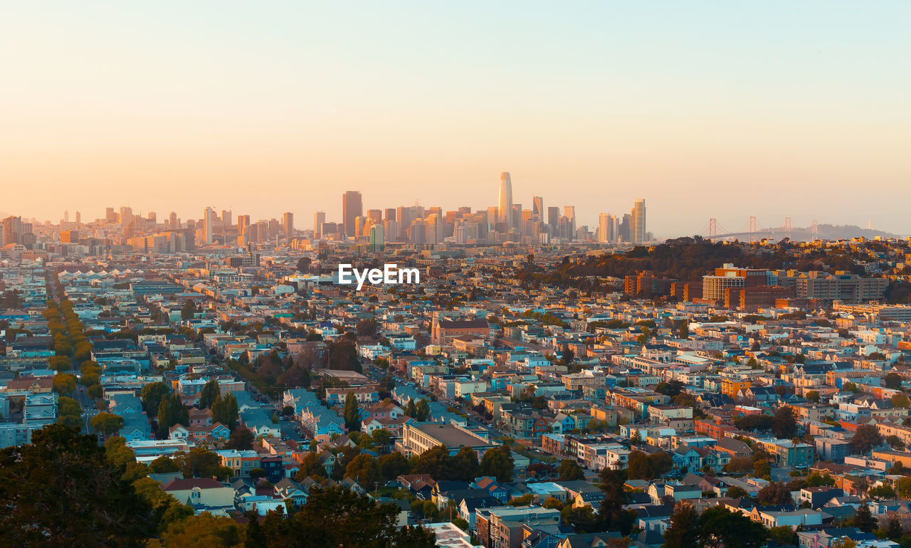 Aerial view of buildings in city against clear sky