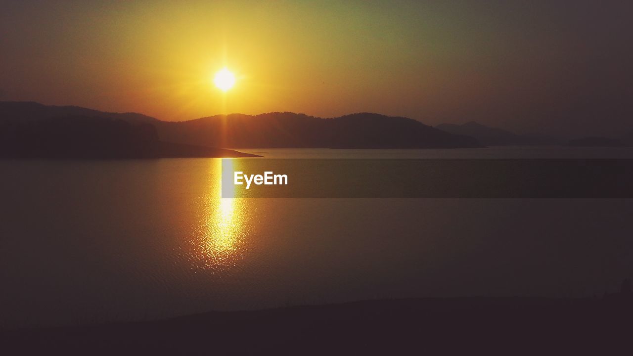 Lake with mountain and sun during sunset