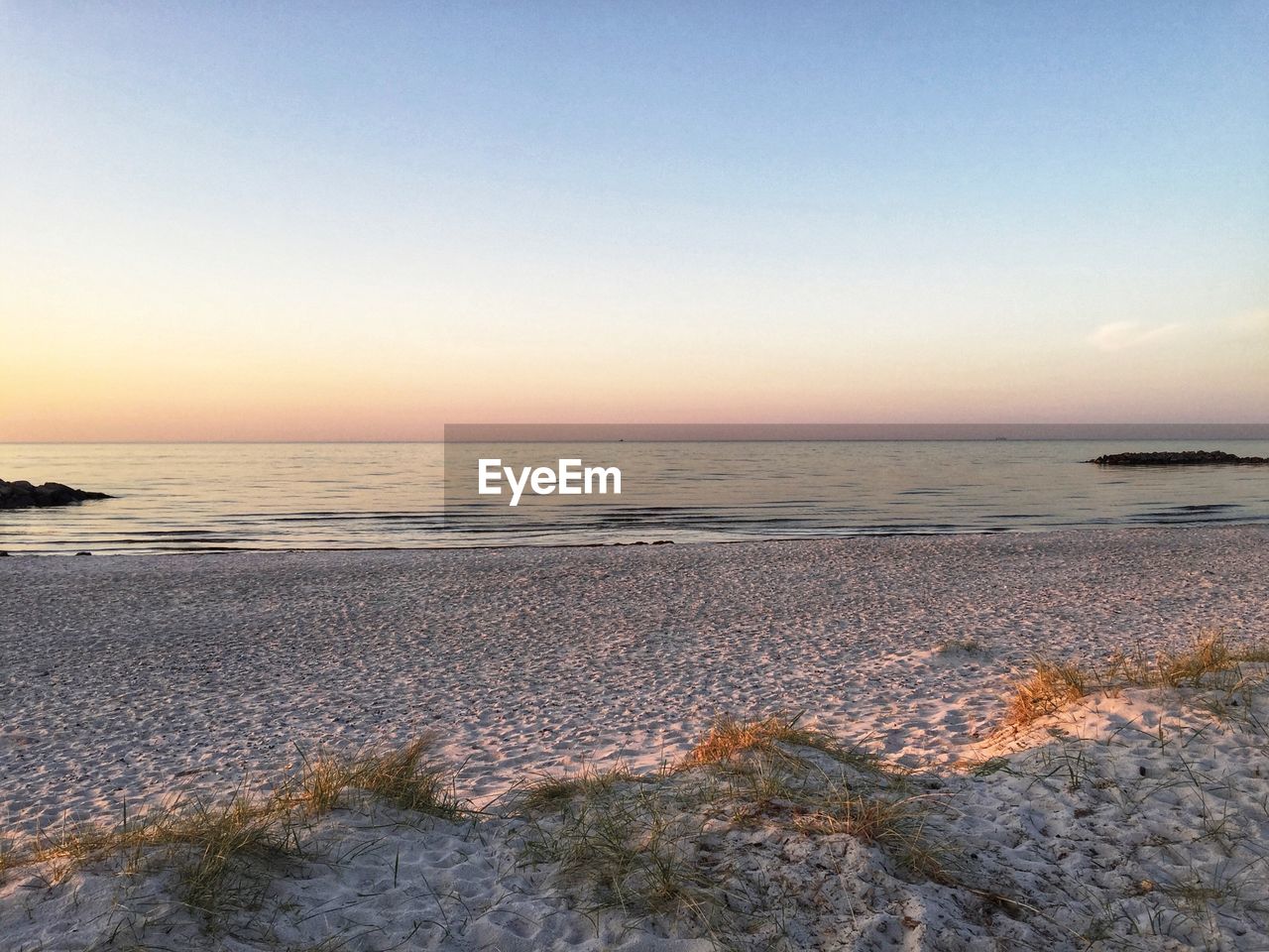 SCENIC VIEW OF BEACH AGAINST SKY DURING SUNSET