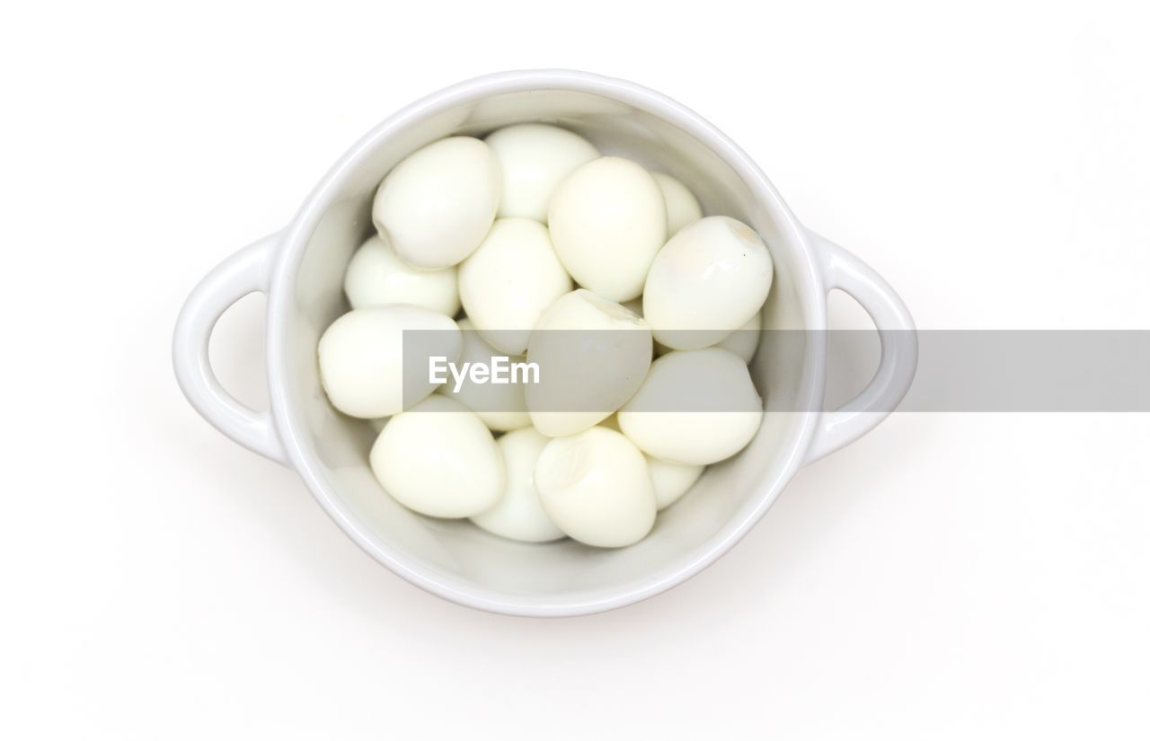 Directly above shot of eggs in bowl against white background