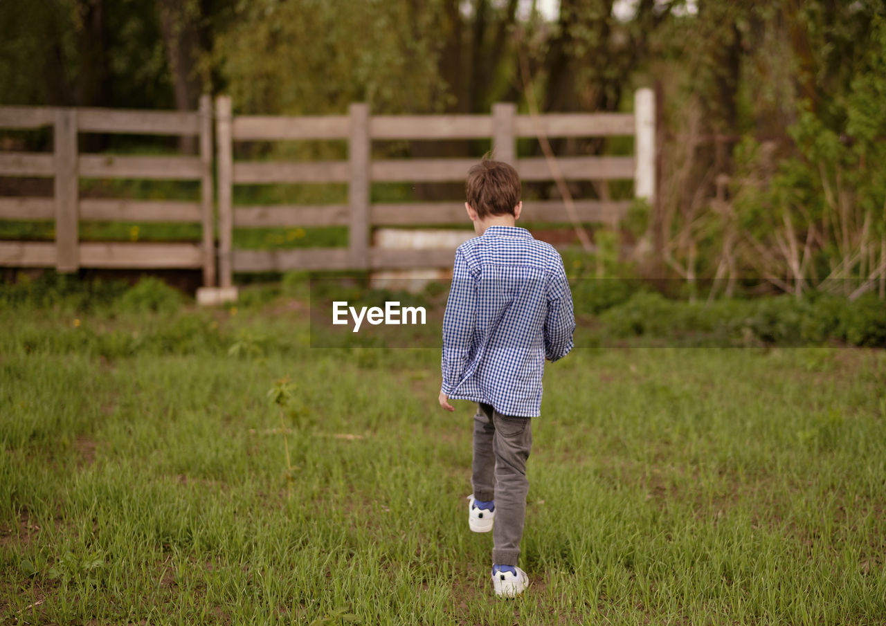 Rear view of boy standing on field