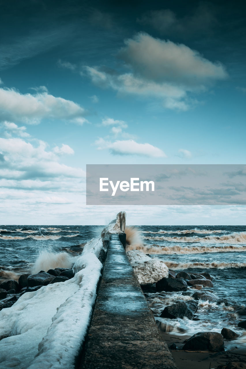 Pier at sea against sky