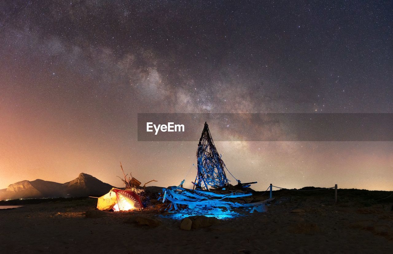 ILLUMINATED TENT AGAINST SKY AT NIGHT DURING SUNRISE