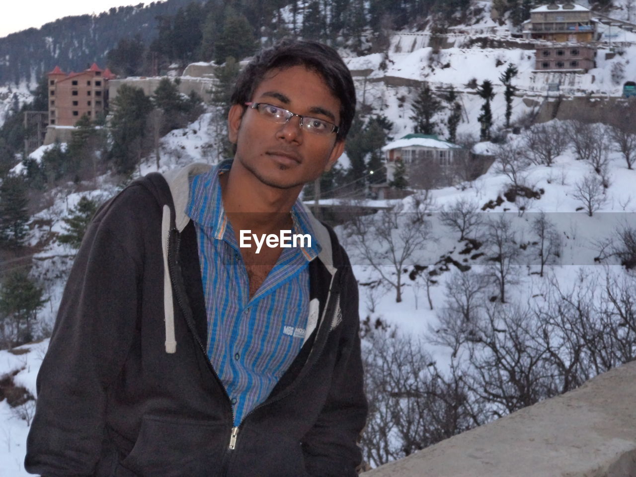 Portrait of smiling man against snow covered mountain