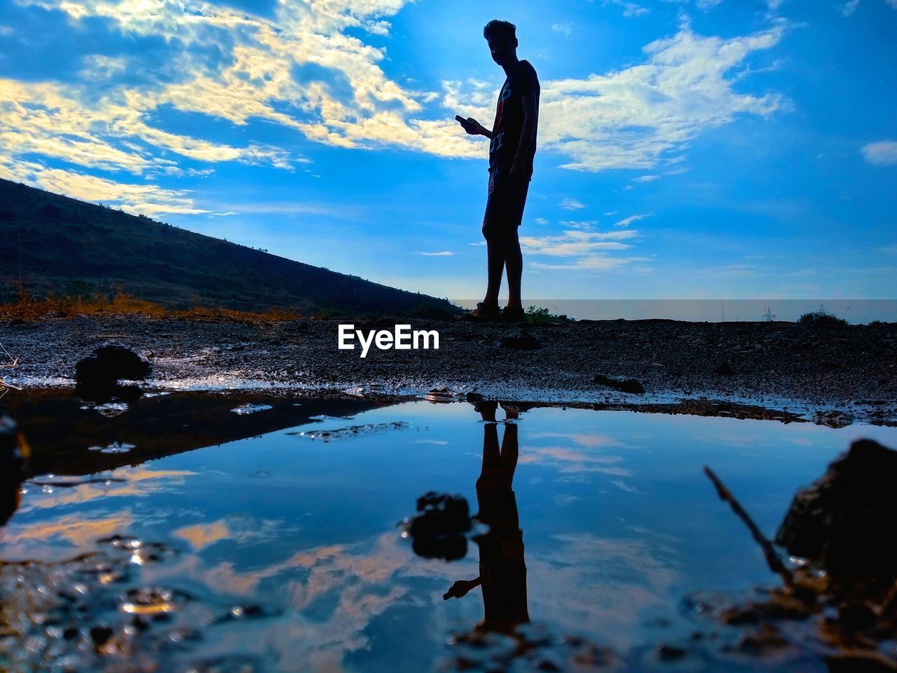 FULL LENGTH OF MAN STANDING ON ROCK