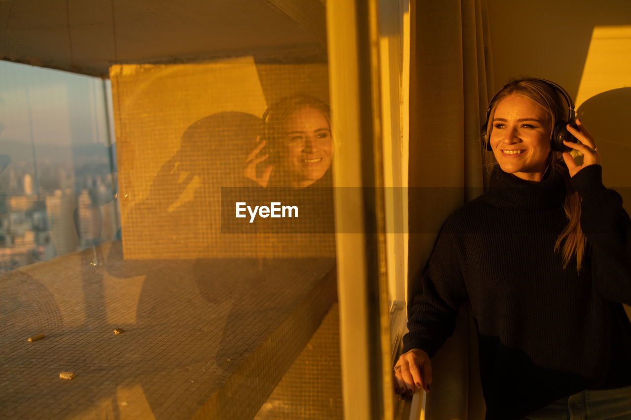 adult, yellow, architecture, smiling, one person, men, portrait, emotion, standing, city, waist up, building exterior, business, window, happiness, women, evening, built structure, clothing, communication, night, lifestyles, building, looking at camera, young adult, looking