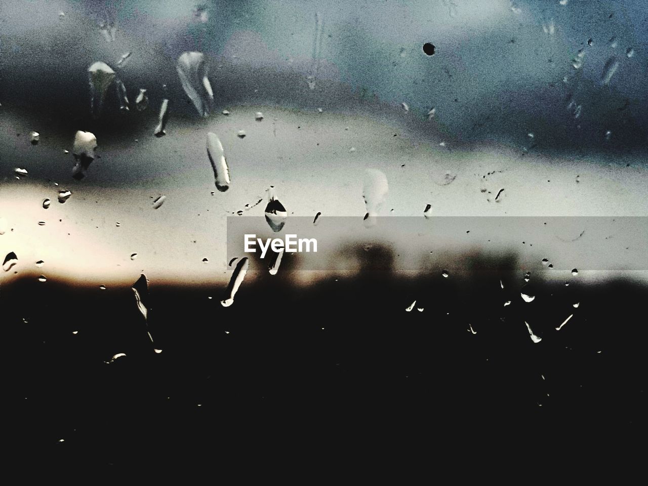 CLOSE-UP OF RAINDROPS ON GLASS WINDOW AGAINST RAINY SEASON