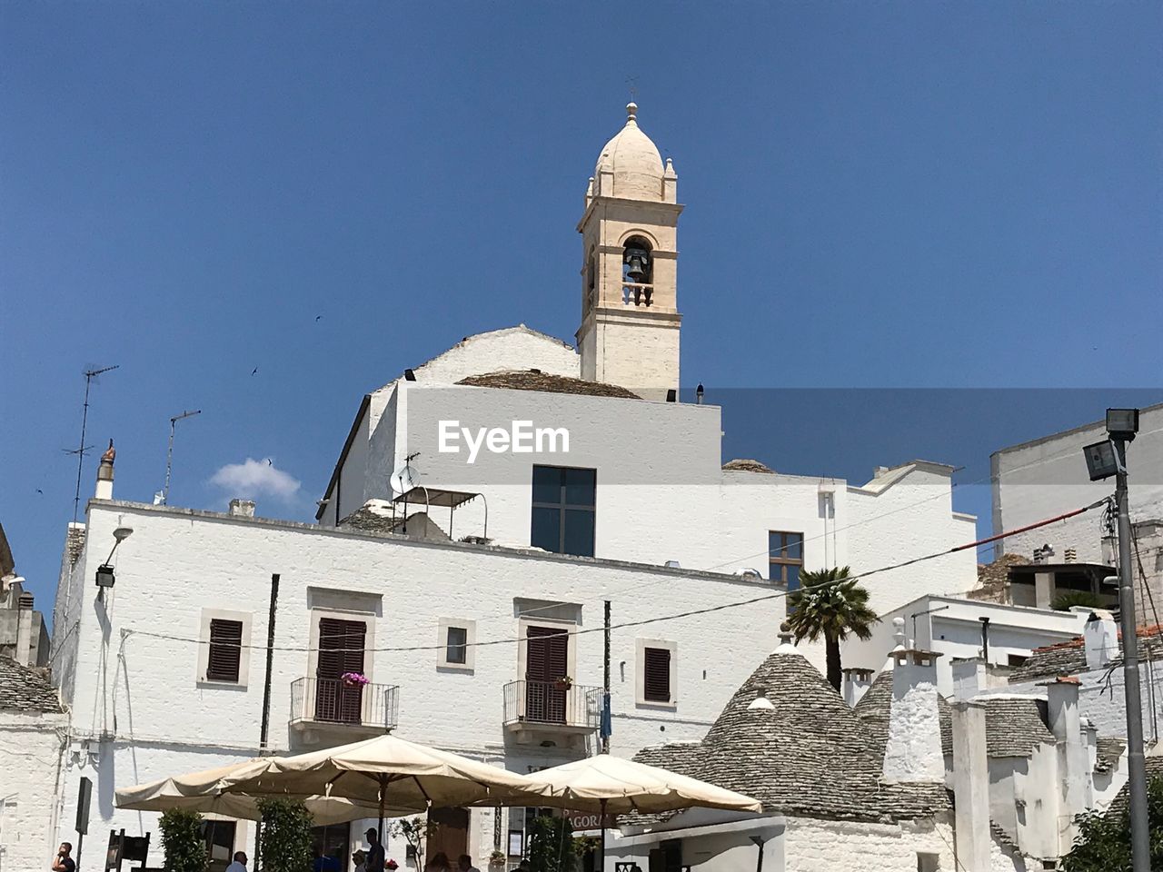 Low angle view of whitewashed buildings in town against blue sky