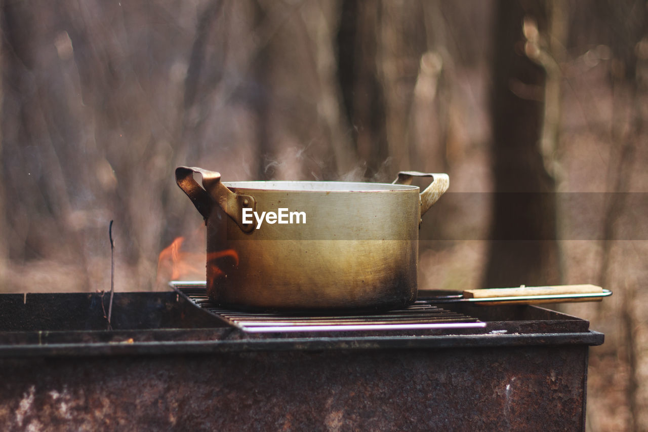 Close-up of metal container on barbecue grill